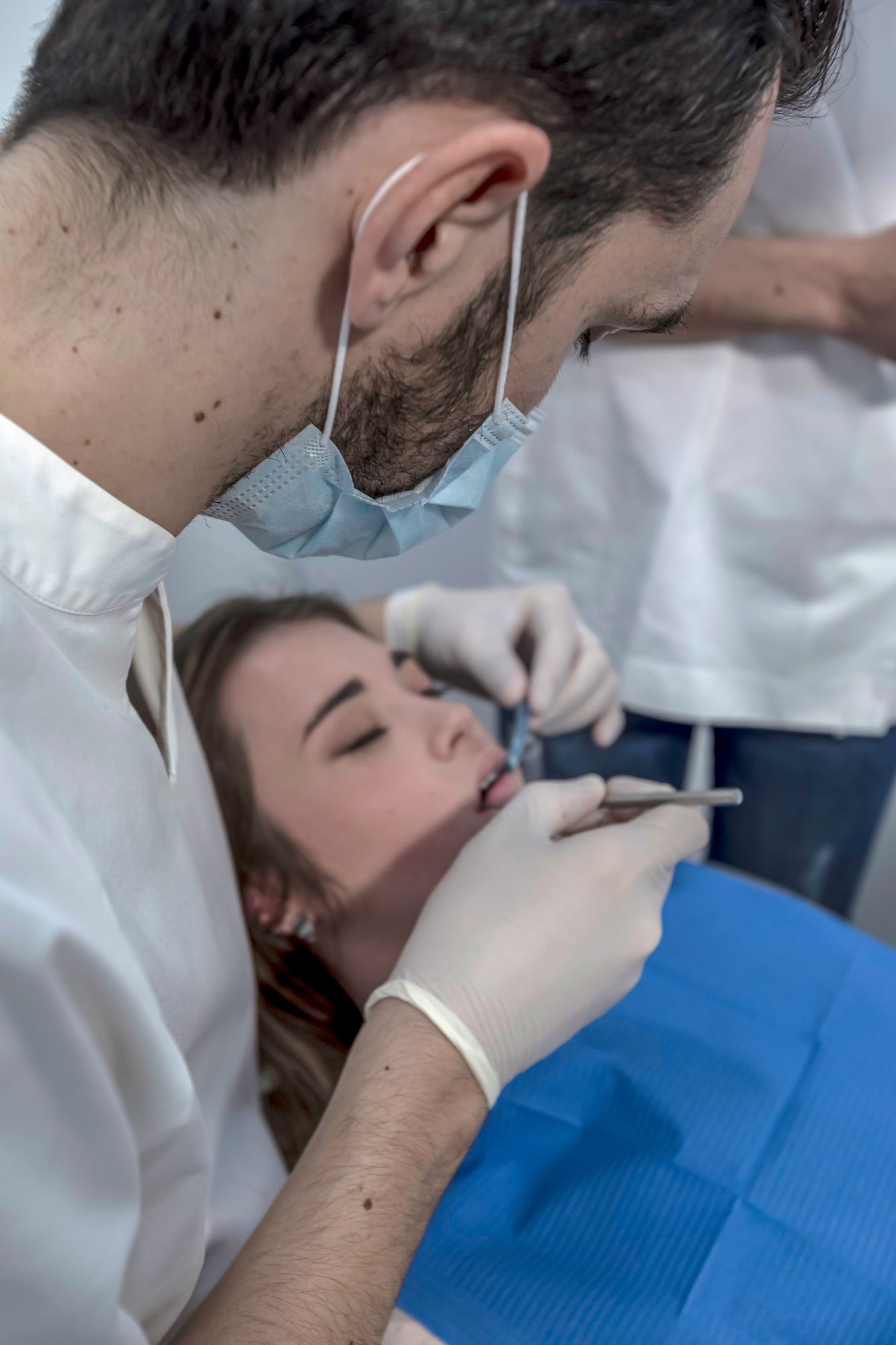 Dentist makes a professional cleaning of the teeth of a young female patient in the dental office.